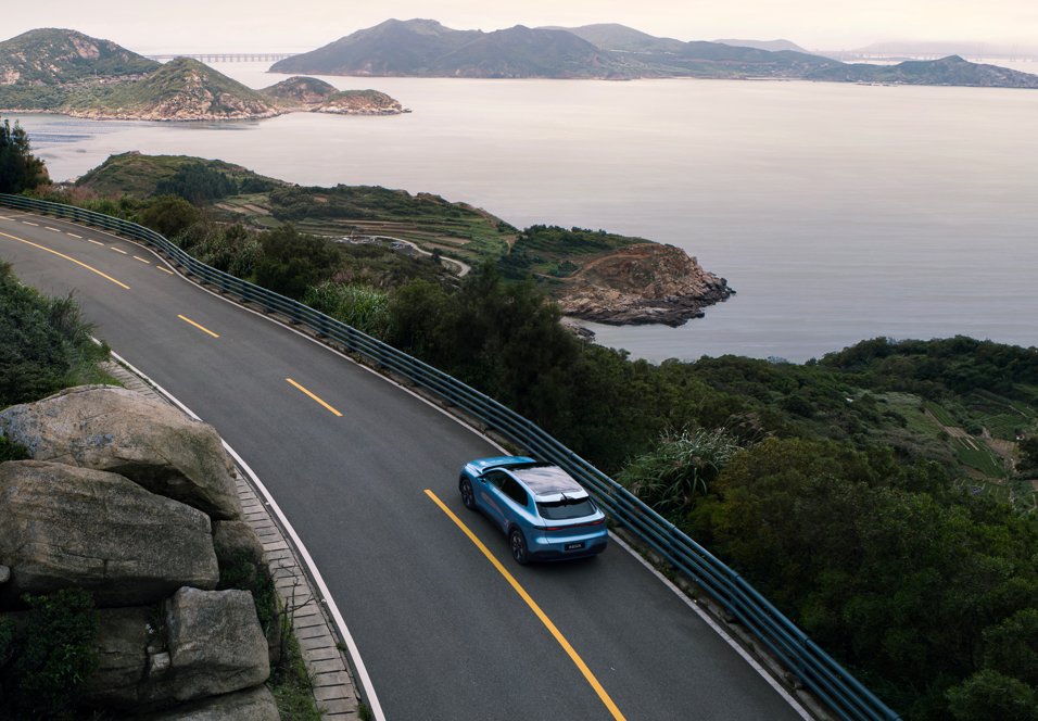 Foto: Changan Deepal S05 i fargen Andromeda Blue i landskap og vann i bakgrunnen